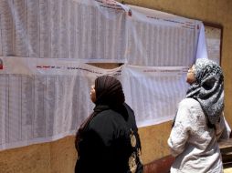 Dos mujeres comprueban sus nombres en las listas electorales durante los comicios presidenciales en un colegio electoral. EFE  /