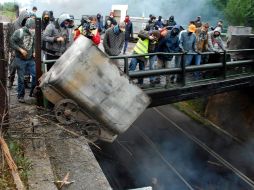Mineros lanzan desde un puente a la carretera contenedores incendiados; desde el 30 de mayo se declaró una huelga indefinida. EFE  /