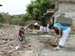 Una vecina de Balcones de la Cantera, una de las zonas más dañadas por la lluvia, despeja su banqueta de basura.  /