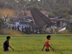 El desplome de un avión en un barrio de Yakarta, Indonesia, causando 10 muertos y varios daños. AP  /