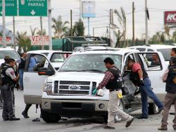 Policías estatales y federales inspeccionan un vehículo luego de los enfrentamientos en la ciudad de Saltillo, Coahuila. AP  /