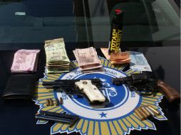 La policía de Guadalajara presentó el dinero y pistolas incautadas a los presuntos delincuentes.  /