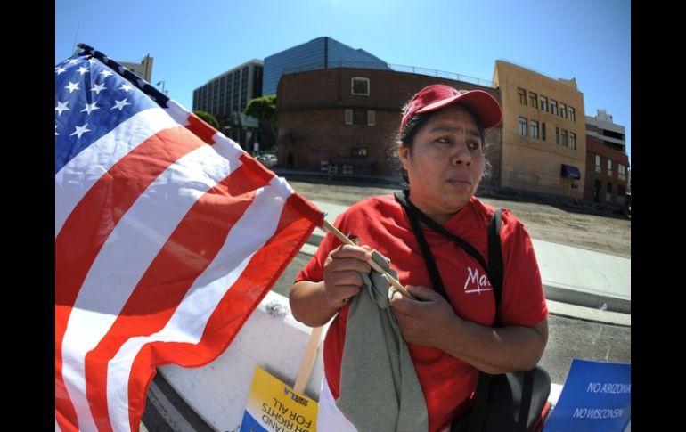 Inmigrante sostiene la bandera de Estados Unidos manifestandose contra la deportación de los ciudadanos extranjeros. ARCHIVO  /