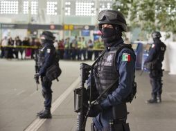 Policías federales custodian la entrada al área de comida en la terminal 2 del AICM. AFP  /
