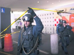 CERCADO. Un policía federal resguarda la zona del crimen, ocurrido en la Terminal 2. AP  /