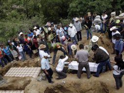 Familiares entierran a sus seres queridos fallecidos en la volcadura del pasado domingo. REUTERS  /