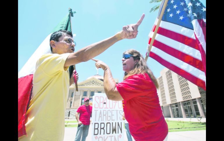 Andy Hernández, con una Bandera mexicana, y Allison Culver, con una bandera de EU, discuten sobre la Ley Antiinmigrante SB1070. AP  /