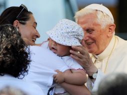 Benedicto XVI bendice a un bebé durante una visita a los damnificados. EFE  /