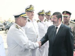 Mohamed Morsi saluda a oficiales junto al ministro egipcio de Interior, Ibrahim Yoused, (derecha), en El Cairo. REUTERS  /