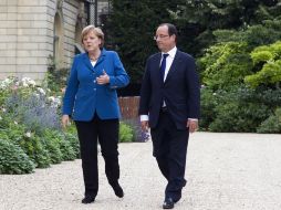 Hollande y Merkel caminan por los jardines del Elíseo, palacio presidencial francés. AFP  /