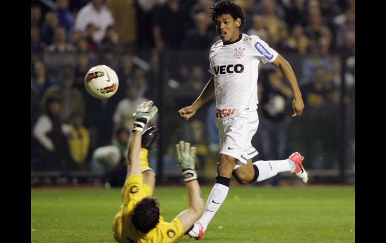 Romarinho (der) dispara ala salida del arquero para el gol del empate de Corinthians. AFP  /