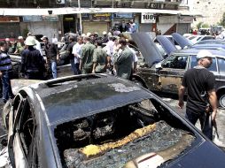 Varias personas observan los daños en los vehículos tras una fuerte explosión registrada en Dmasco. EFE  /