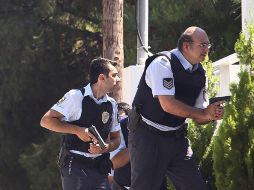 Agentes de policía griegos persiguen a dos sujetos armados durante un incidente en el barrio de Kifissia, Atenas. EFE  /
