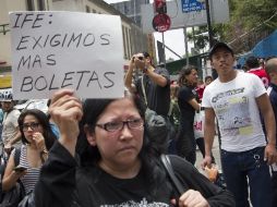 Una de las inconformes muestra un cartél con su petición de más boletas. AFP  /