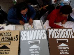 Personas verifican las boletas válidas antes de contar los votos. AP  /