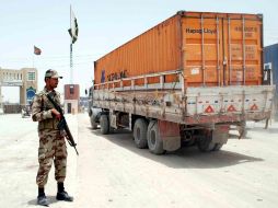 Un camión con suministro logístico para las fuerzas de la OTAN en Afganistán, junto a un guarda fronterizo. EFE  /