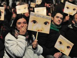 Manifestantes escuchan la sentencia al ex dictador argentino Jorge Rafael Videla, condenado a 50 años de cárcel por robo de bebés. EFE  /