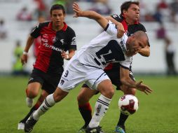 Emanuel Villa de Pumas disputa el balón con Leandro Cufré del Atlas durante el partido. MEXSPORT  /