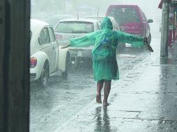 Aunque las lluvias han generado daños en la ZMG, siempre son bienvenidas, como hace esta niña en una calle de la colonia Polanco.  /