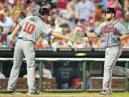 Bravos al ataque. Chipper Jones felicita a Brian McCann, tras anotar mediante un jonrón con la casa llena. AFP  /