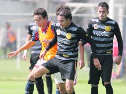 El defensa de Leones, Juan Manuel García Zavala (centro), trata de quitarle el balón al delantero chiva, Érick “Cubo” Torres. CORTESÍA  /