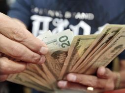 El tipo de cambio para solventar obligaciones denominadas en moneda extranjera pagaderas en la República es de 13.3449 pesos. ARCHIVO  /