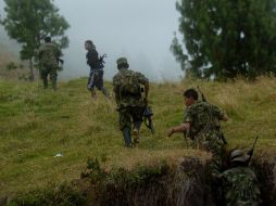 Varios miembros de las Fuerzas Armadas Revolucionarias de Colombia (FARC) se dirigen a un refugio. EFE  /