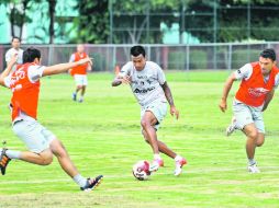 GUARIDA DEL ZORRO. Alonso “El Negro” Sandoval trata de avanzar en medio de dos suplentes de Atlas.  /