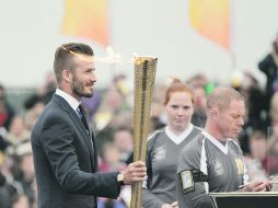 HASTA EN LA SOPA. Beckham fue el encargado de encender la Antorcha cuando ésta llegó a territorio inglés procedente de Grecia.  AFP  /