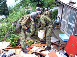 Soldados japoneses buscando supervivientes entre los escombros tras las fuertes lluvias en la ciudad de Aso. EFE  /