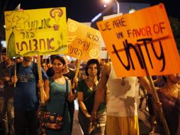 Manifestantes israelíes tienen pancartas mientras marchan en una calle de Tel Aviv. REUTERS  /