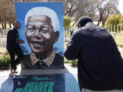 Un hombre junto a un retrato del ex presidente sudafricano Nelson Mandela. ONU pide 67 minutos de labor comunitaria para festejarlo.EFE  /
