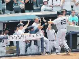 Bien hecho. Mark Teixeira es felicitado por sus compañeros en el dugout. AFP  /