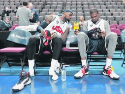 LeBron James y Kevin Durant revisan una guía donde figura el roster de Gran Bretaña, su próximo rival en la preparación previa. AFP  /