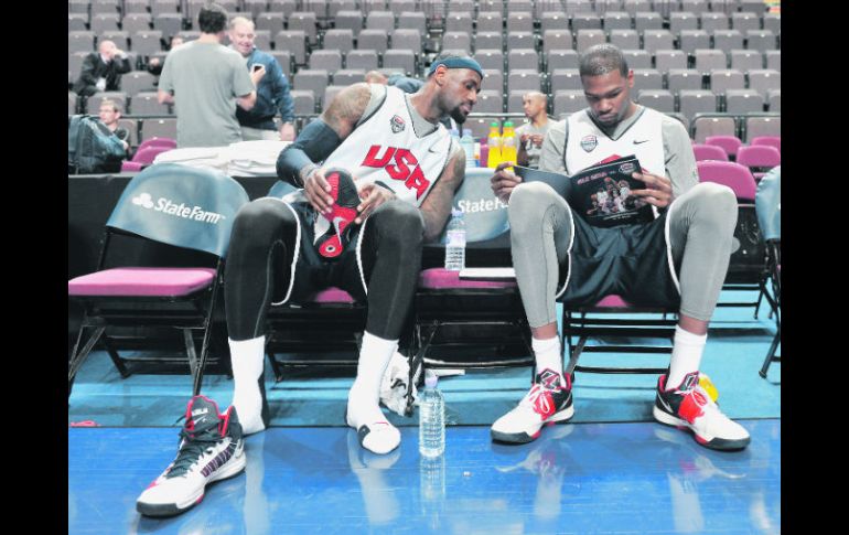 LeBron James y Kevin Durant revisan una guía donde figura el roster de Gran Bretaña, su próximo rival en la preparación previa. AFP  /