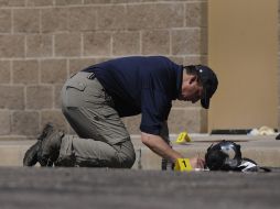 Un investigador revisa el suelo en el lugar del crimen. AP  /