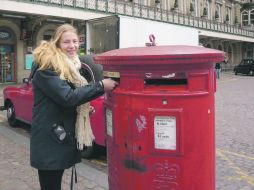 Véanlos bien. Una residente de Londres deposita una carta en el tradicional buzón de la ciudad. ESPECIAL  /