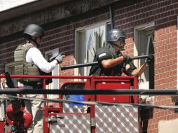 Agentes de policía usan una cámara de vídeo para inspeccionar la vivienda del supuesto autor de la matanza de Denver, James Holmes. EFE  /