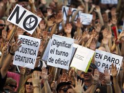 Manifestantes sostiene pancartas que enuncian frases como 'dignifica el turno de oficio'. AP  /