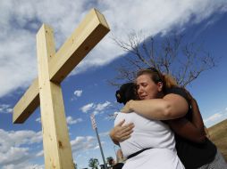 Naomi Hicks (D) abrazaa una amiga detrás del teatro, donde un hombre armado abrió fuego contra los aficionados al cine en Aurora.REU  /