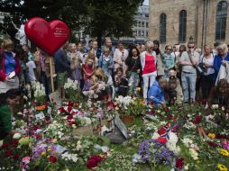 Personas dejan flores afuera de la catedral de Oslo, Noruega. AP  /
