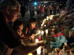 Familiares, amigos y comunidad en general ha expresado sus homenajes y condolencias a los doce muertos por el tiroteo. AP  /