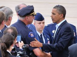 Barack Obama (D), abraza al jefe de la Policía de Aurora, Dan Oates, en la Base de la Fuerza Aérea de Buckley. EFE  /