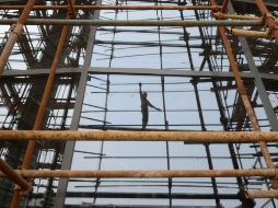 Reflejo de un trabajador en Taiyuan, China. Los empleados buscarían nuevas ventanas de oportunidad en vez de cerrar puertas. ARCHIVO  /