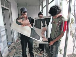 Soldados del Ejército Libre Sirio destruyen un retrato de Bashar al Assad en el cruce de la frontera de Al-Salam de Bab a Turquía. AFP  /