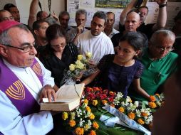 El féretro cubierto de flores atravesó lentamente el pasillo hasta el altar del templo. EFE  /