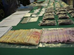 Se les aseguraron 51 mil 800 pesos en efectivo, dos armas de fuego, 21 bolsas con mariguana y 21 envoltorios de piedra base. ESPECIAL  /