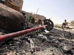 Varios soldados iraquíes inspeccionan el escenario del ataque con coche bomba en distrito chií de Sadr City, en Bagdag. EFE  /