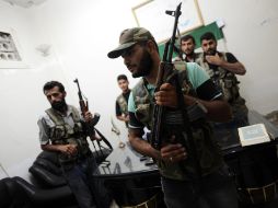 Rebeldes sirios toman sus armas dentro de la base militar Tecvid Sicco, al norte de la ciudad de Aleppo. EFE  /