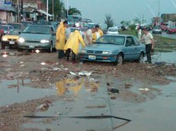Un automóvil se quedó atascado entre la tierra que cayó del cerro.  /
